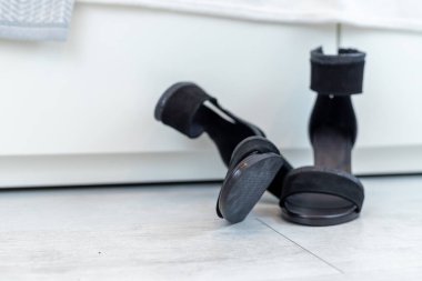 Beyaz bir gardırobun önünde yüksek topuklu siyah klasik sandaletler. Yüksek kalite fotoğraf