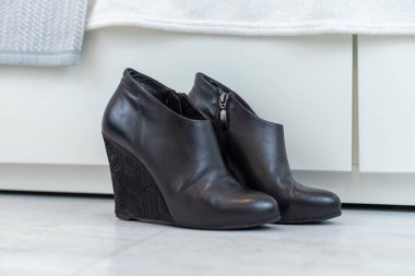 Beyaz bir dolabın önünde yüksek topuklu siyah çizmeler. Yüksek kalite fotoğraf