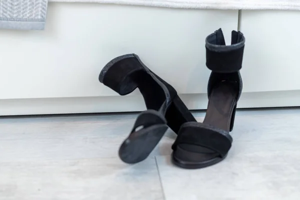 black classic sandals with high heels in front of a white wardrobe. High quality photo