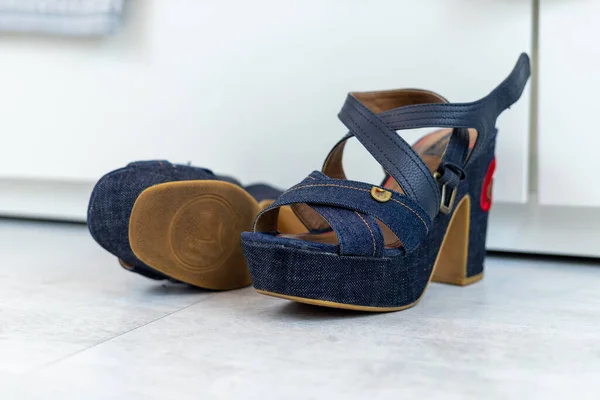 Blue Jeans shoes with a high heel in front of a white closet. High quality photo