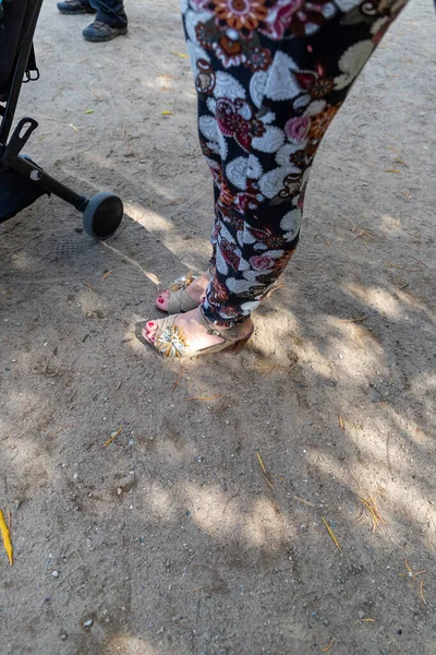 Low Section of Woman with colorful trousers and shoes with wedge heel pushes stroller, floor recording. High quality photo