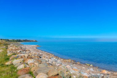 Rocky beach by the sea in Denmark with blue sky. High quality photo