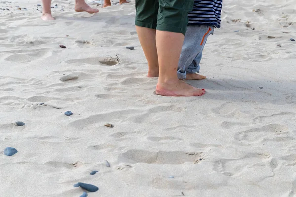 Women and baby feet walk on the beach in the sand. High quality photo