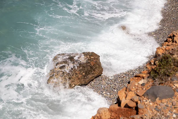 Girit 'teki deniz kıyısında deniz taşları ve dalgalar var. Yüksek kalite fotoğraf