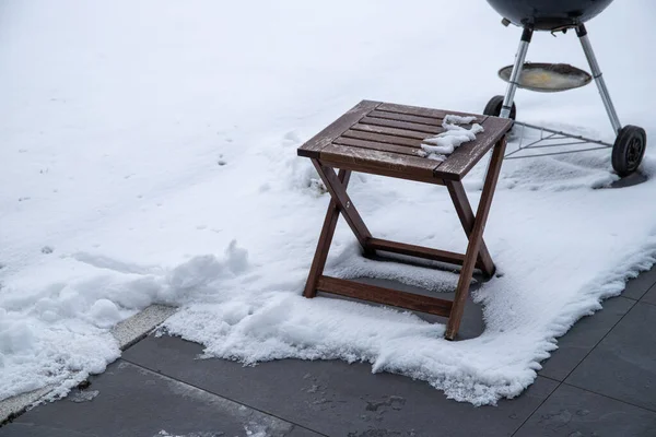 small wooden table in the snow at a barbecue. High quality photo