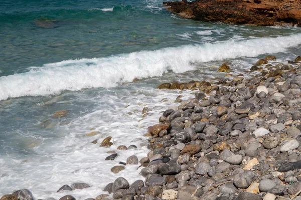 Sea coast in Crete with stones in the sea and waves. High quality photo