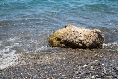 Girit 'teki deniz kıyısında deniz taşları ve dalgalar var. Yüksek kalite fotoğraf