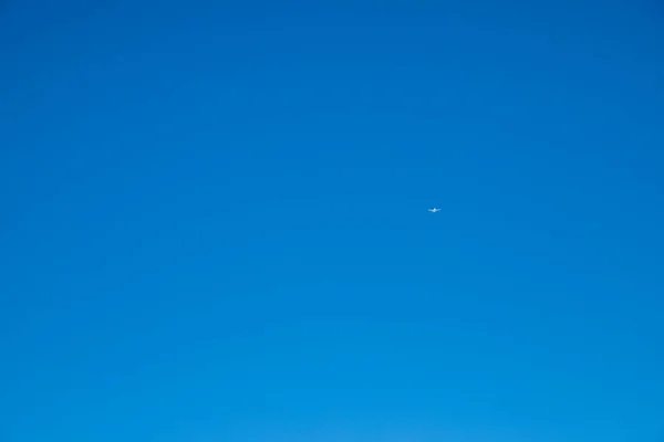 stock image white plane in a deep blue sky. High quality photo