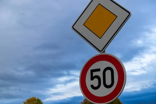 road sign with 50 kroad sign with 50 kmh and right of way, Germany in autumnmh and right of way, Germany in autumn. High quality photo