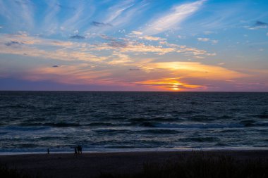 Kum tepeleri arasında Danimarka sahilinden Kuzey Denizi 'ne gün batımı. Yüksek kalite fotoğraf