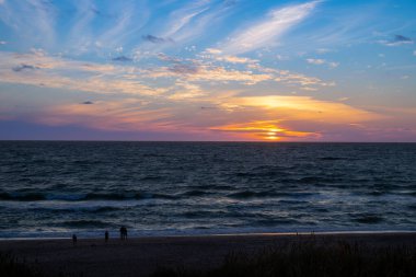 Kum tepeleri arasında Danimarka sahilinden Kuzey Denizi 'ne gün batımı. Yüksek kalite fotoğraf