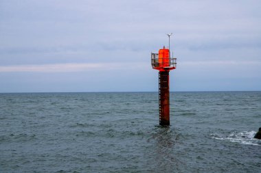 Okyanus limanı girişinde ışığı olan kırmızı bir direk. Yüksek kalite fotoğraf