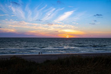 Kum tepeleri arasında Danimarka sahilinden Kuzey Denizi 'ne gün batımı. Yüksek kalite fotoğraf