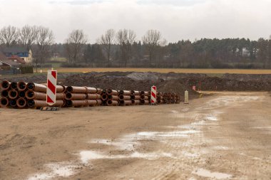 Sonbaharda kahverengi kanalizasyon boruları olan ıslak bir inşaat alanı. Yüksek kalite fotoğraf