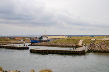 Arka planda mavi bir gemi olan gemiler için Jetty. Torsminde, Danimarka. Yüksek kalite fotoğraf