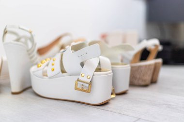 Aydınlık bir zeminde, topuklu beş çift beyaz kadın ayakkabısı. Yüksek kalite fotoğraf