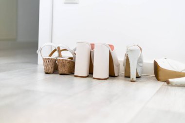 Aydınlık zeminde, topuklu üç çift beyaz kadın ayakkabısı. Yüksek kalite fotoğraf