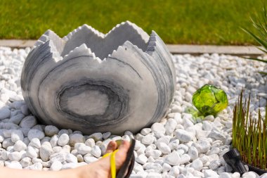 Bir kadın, beyaz taş bir yatağın ve mermer sütunların önündeki duvara parmak arası terliklerle ayaklarını koyar. Yüksek kalite fotoğraf