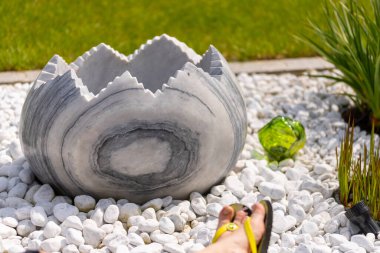 Bir kadın, beyaz taş bir yatağın ve mermer sütunların önündeki duvara parmak arası terliklerle ayaklarını koyar. Yüksek kalite fotoğraf