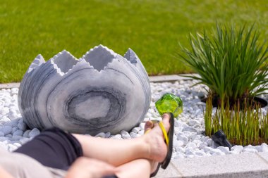 Bir kadın, beyaz taş bir yatağın ve mermer sütunların önündeki duvara parmak arası terliklerle ayaklarını koyar. Yüksek kalite fotoğraf