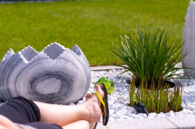 Bir kadın, beyaz taş bir yatağın ve mermer sütunların önündeki duvara parmak arası terliklerle ayaklarını koyar. Yüksek kalite fotoğraf