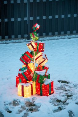 Noel hediyesi paketleri birikmiş. Süslenmek için kardaki direğe ışık tutulmuş. Yüksek kalite fotoğraf