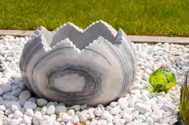 Taş bir yataktaki çeşme gibi büyük kırık mermer yumurta. Yüksek kalite fotoğraf