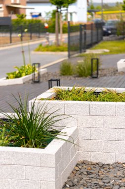 İçi ot dolu doğal taş tuğlalardan yapılmış kaldırılmış yatak, arka planda sokak. Yüksek kalite fotoğraf