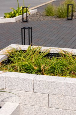İçi ot dolu doğal taş tuğlalardan yapılmış kaldırılmış yatak, arka planda sokak. Yüksek kalite fotoğraf