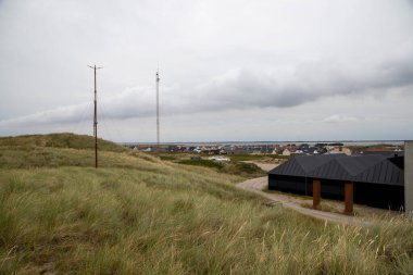 small settlement behind a dune with grass landscape in Denmark. High quality photo