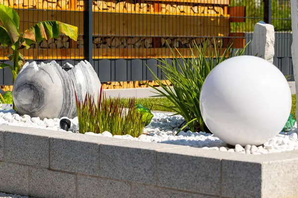 Mermer Taş Yataklı Granit Duvar, Beyaz Balo Lambası Çimenleri ve Mermer Çeşmeli. Yüksek kalite fotoğraf