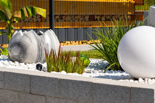 Mermer Taş Yataklı Granit Duvar, Beyaz Balo Lambası Çimenleri ve Mermer Çeşmeli. Yüksek kalite fotoğraf
