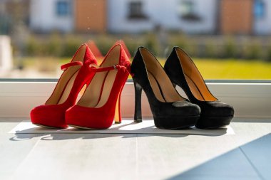 Yerde, pencerenin önünde, peş peşe iki çift kadın ayakkabısı. Yüksek kalite fotoğraf