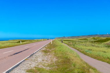 Kum tepelerinin arasındaki yol Danimarka sahillerinde çimlerle kaplıydı. Yüksek kalite fotoğraf
