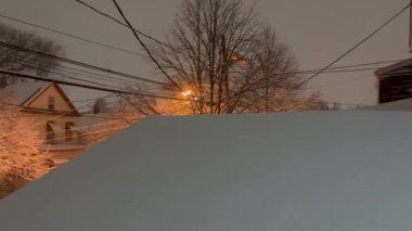 Bir kar fırtınası tasvir eden, sıcak bir kış atmosferi yaratan dramatik bir kar gecesi sahnesi..