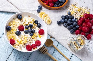tasty meal with yoghurt, banana, berries and cereals