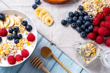 tasty meal with yoghurt, banana, berries and cereals