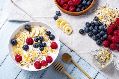 tasty meal with yoghurt, banana, berries and cereals