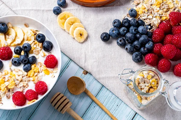tasty meal with yoghurt, banana, berries and cereals