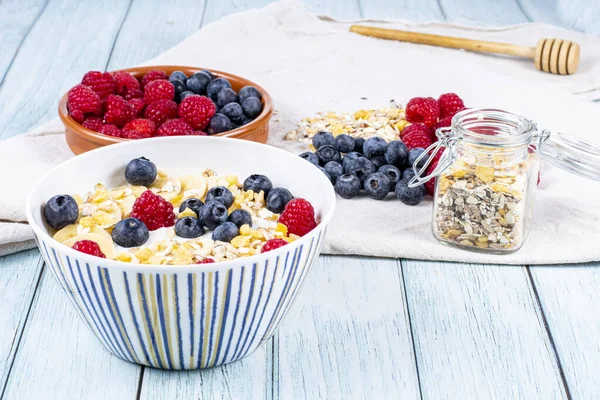 tasty meal with yoghurt, banana, berries and cereals