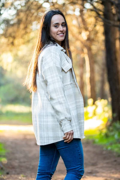 young girl relaxes walking through a beautiful forest at sunset