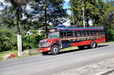 Guatemala - 24 Haziran 2014: Guatemala 'daki topluluklar arasında mal ve insan taşıyan renkli, modifiye edilmiş ve dekore edilmiş otobüs.