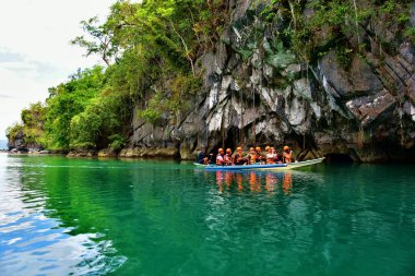 Palawan, Philippines - tourists on the boats visiting Puerto Princesa subterranean underground river clipart