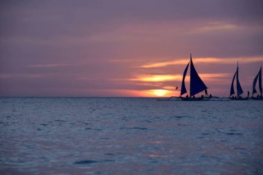 Filipinlerde yelkenli tekneleriyle güzel turuncu tropikal gün batımı