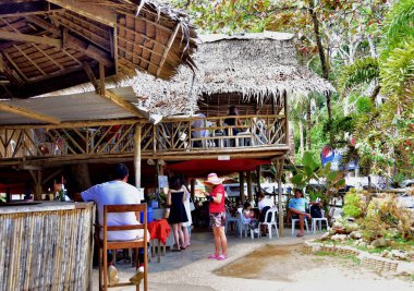 Palawan, Filipinler - Şubat 2019: Puerto Princesa sahilindeki bungalovlarda dinlenen insanlar