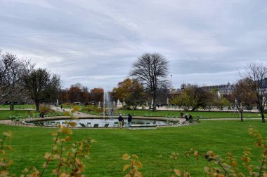 Paris, Fransa - 27 Kasım 2022: Fransa 'nın Paris kentindeki Tuileries Garden' da heykelleri olan ara sokağı ziyaret eden turistler