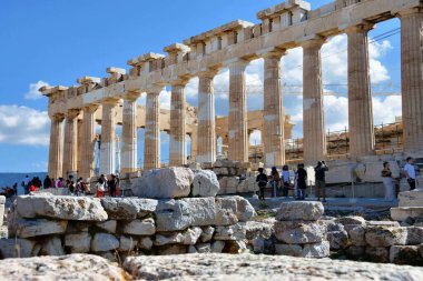 Atina, Yunanistan, 18 Ekim 2021: Turistler güneşli bir günde Parthenon tapınağını ziyaret ediyorlar. Atina, Yunanistan 'da Akropolis. Parthenon, Yunanistan 'daki Atinalı Akropolis tapınağı olup tanrıça Athena' ya adanmıştır..