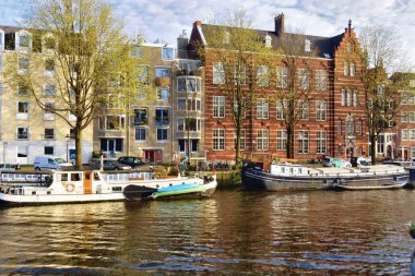 Amsterdam, Hollanda - 7 Nisan 2023: Şehrin merkezindeki Amsterdam kanallarının çarpıcı manzarası.