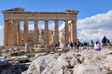 Atina, Yunanistan, 18 Ekim 2021: Turistler güneşli bir günde Parthenon tapınağını ziyaret ediyorlar. Atina, Yunanistan 'da Akropolis. Parthenon, Yunanistan 'daki Atinalı Akropolis tapınağı olup tanrıça Athena' ya adanmıştır..