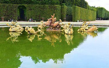 Versailles, Fransa - 18 Haziran 2023 Versailles Sarayı 'nın güzel bahçesindeki ejderha çeşmesi.